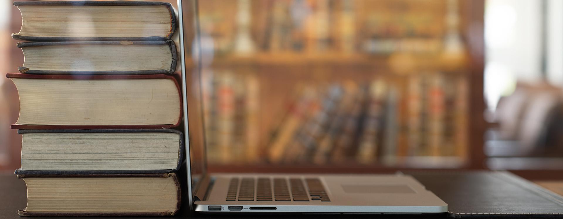 Laptop and books on table in library